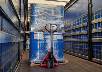 Bidons bleus sur palettes sur un transpalette